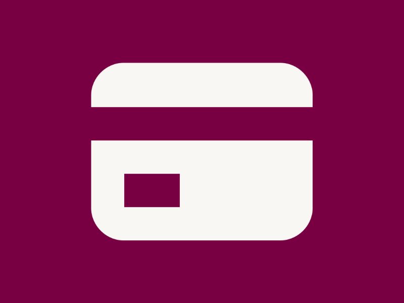 A white credit card on a plum red background.