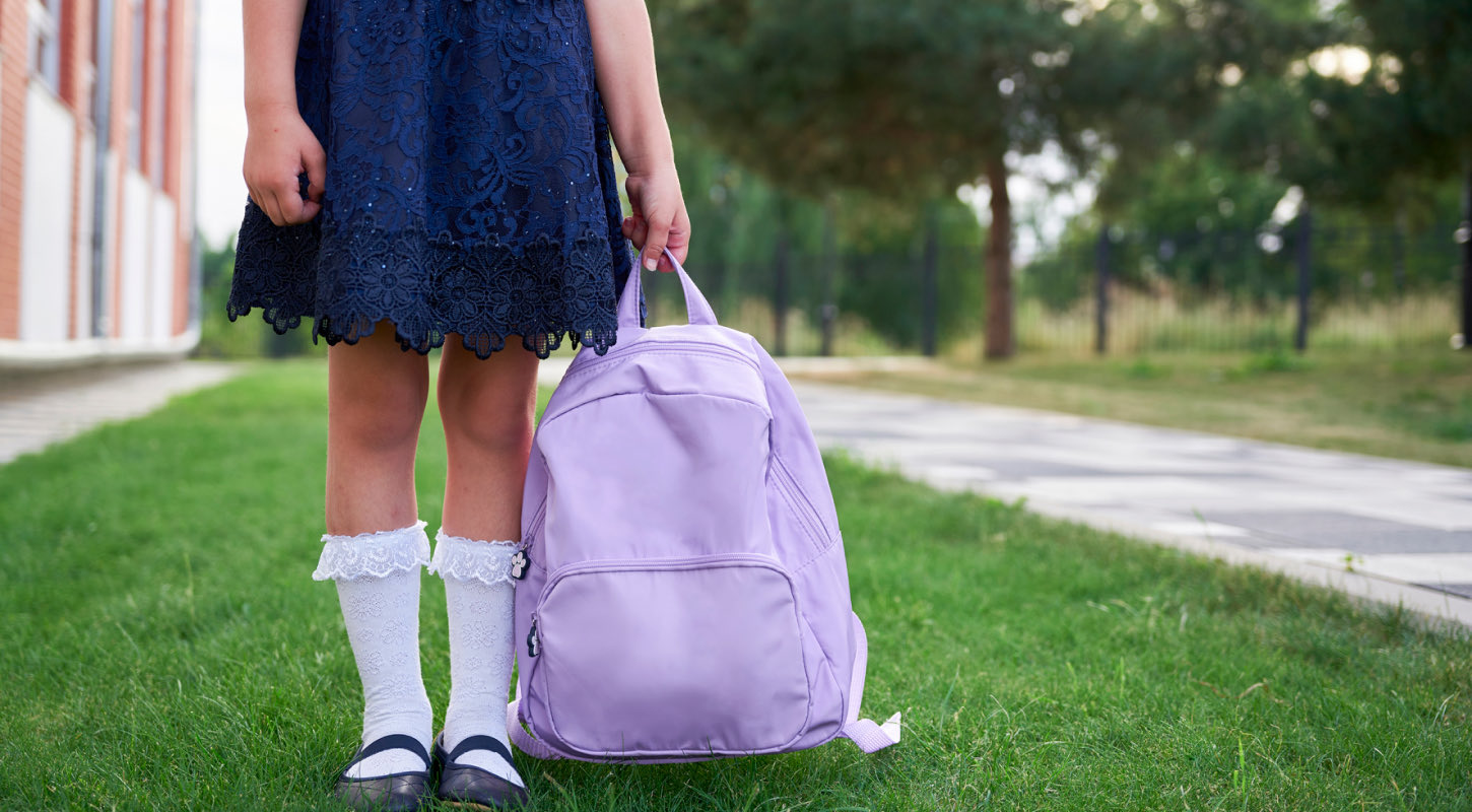 Girl holding purple backpack