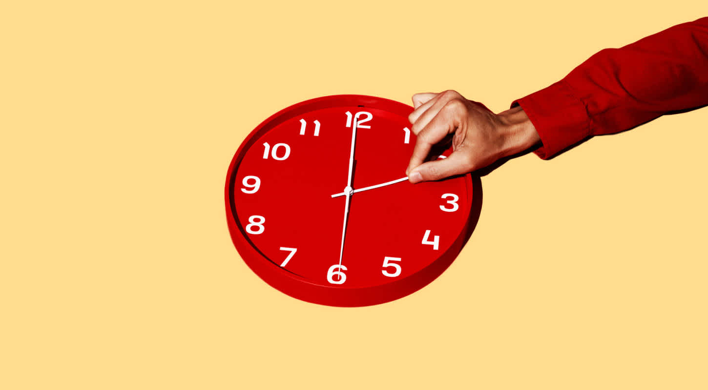 A person's finger tracks the minute hand on a clock measuring how long life insurance coverage takes.