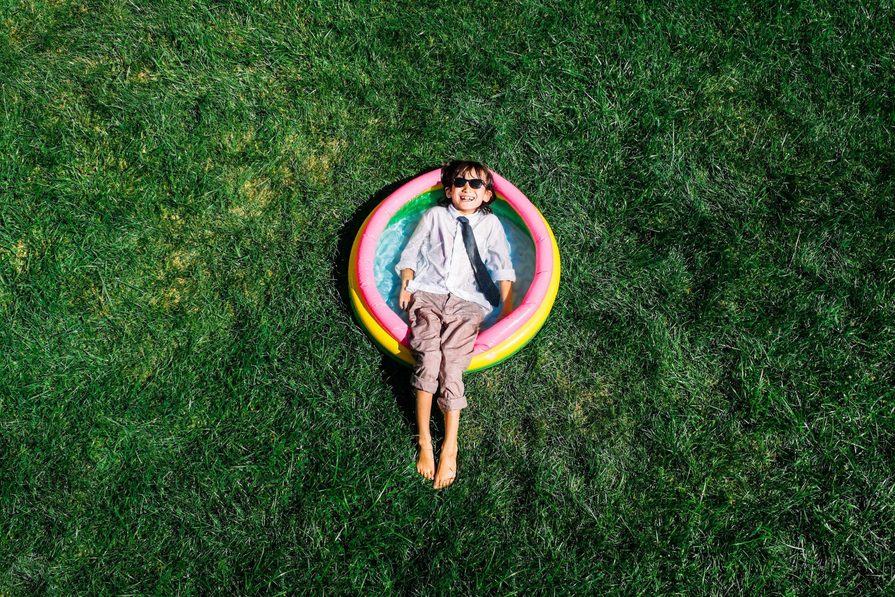 what to know when you have a 10 year old - boy in fancy clothes laughing in backyard pool
