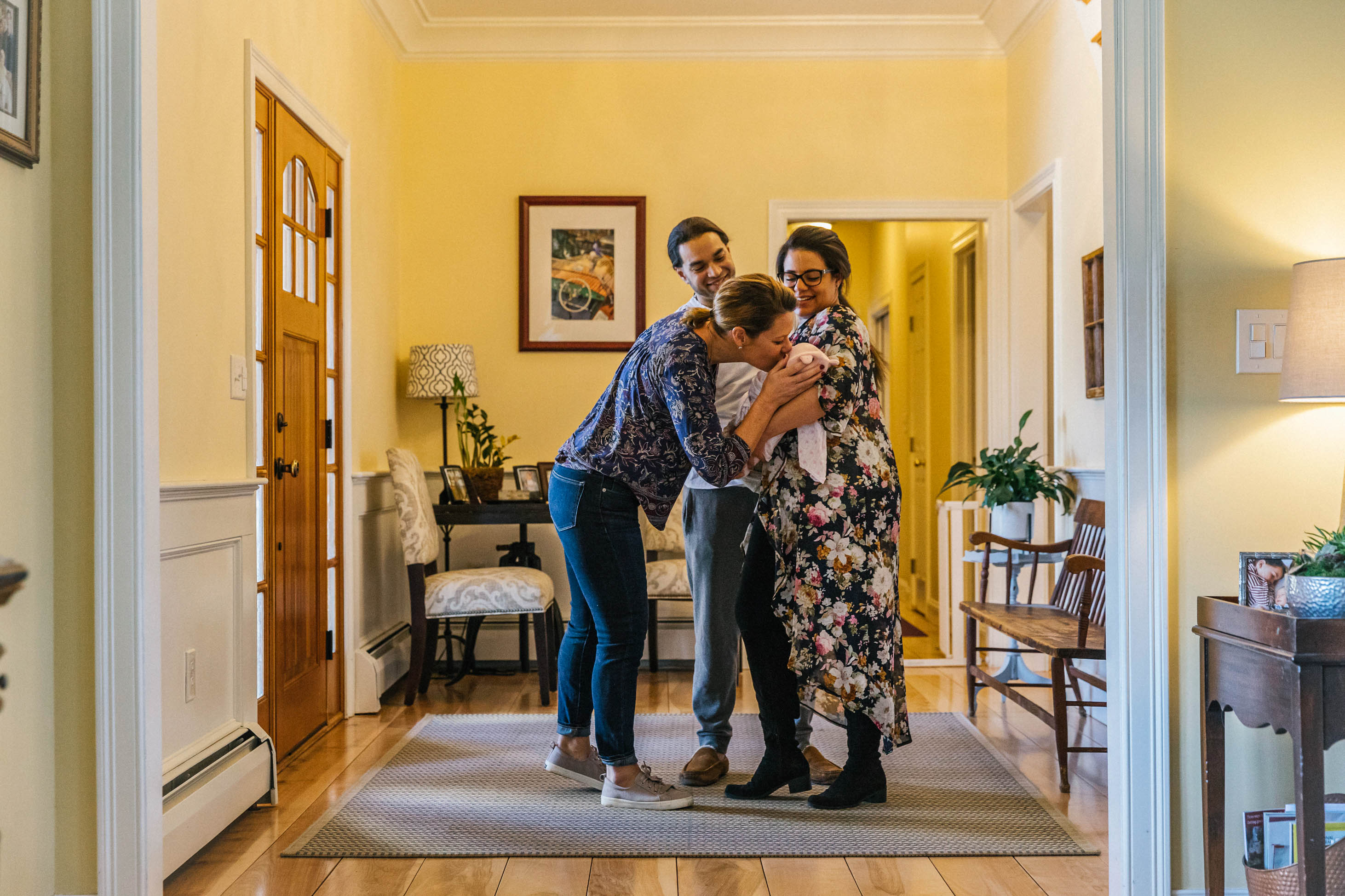 what's the difference between a godparent vs legal guardian - person greeting couple holding baby inside house