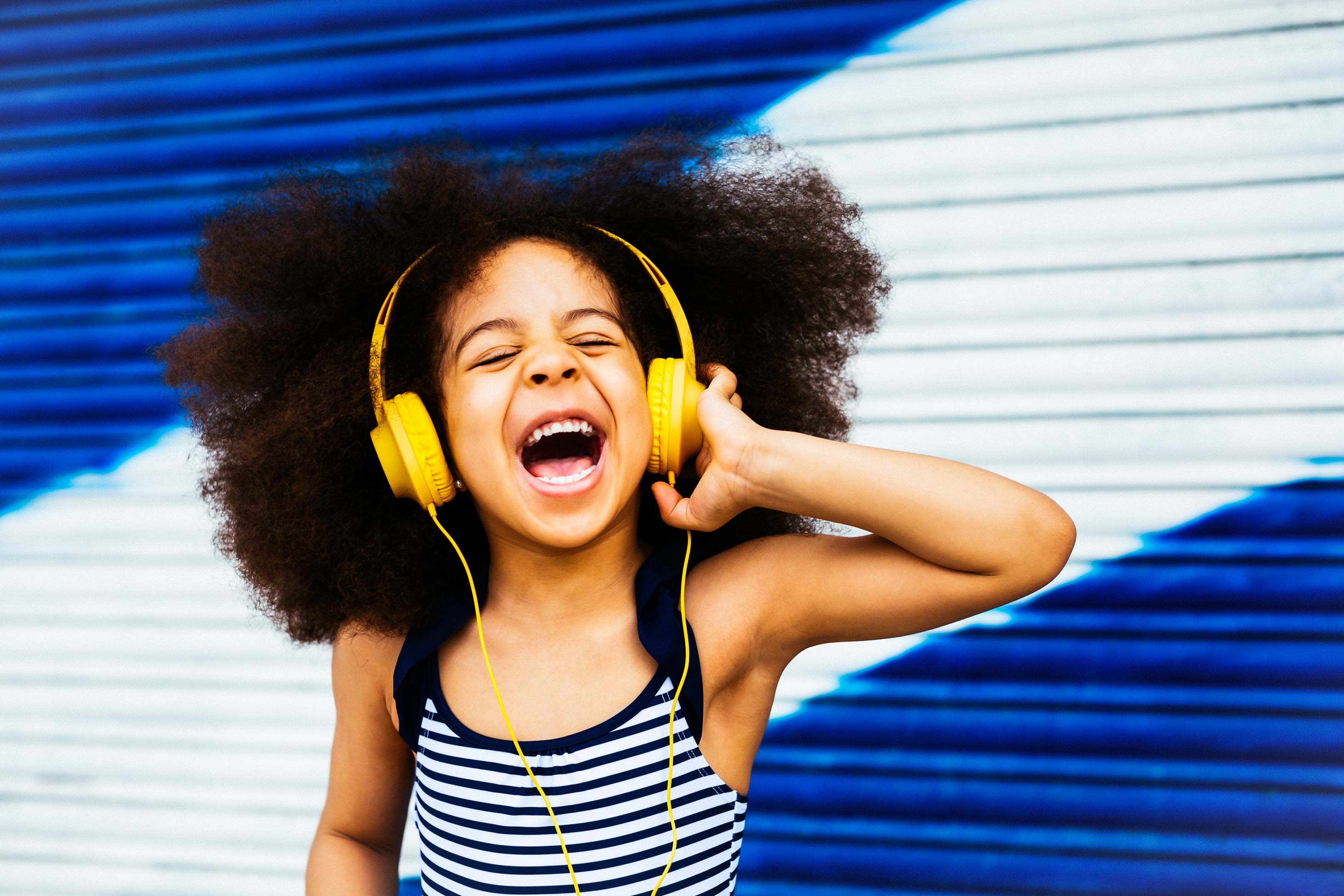 what to know when you have a 6 year old - smiling girl listening to headphones