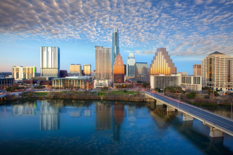 The Best-Paying Cities for Millennials - Austin, Texas skyline with the Ann W. Richards Congress Ave Bridge crossing over the Lady Bird Lake in the foreground. 