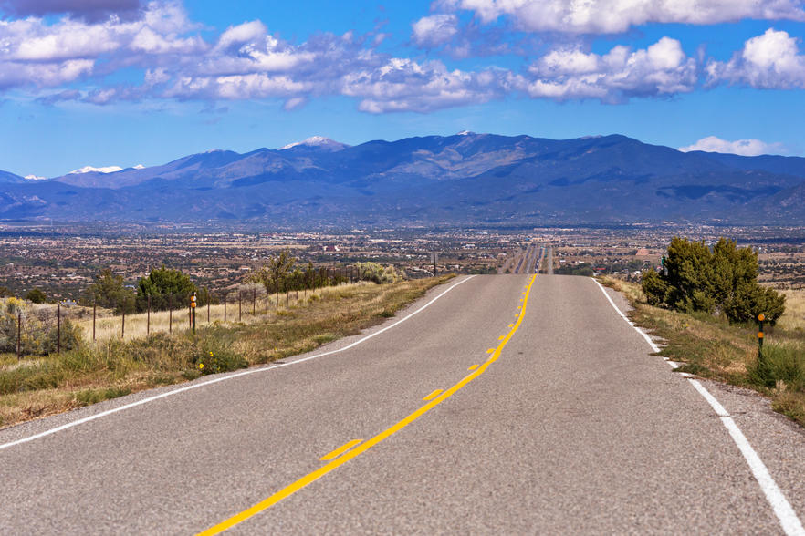 States with the biggest debt problem - Desolate highway on a desert in rural New Mexico with mountains in the background. 