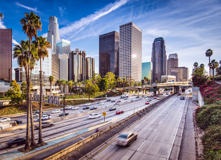 How Much Home Can Millennial Families Afford in These Top Cities? - Los Angeles skyline with a freeway in the foreground. 