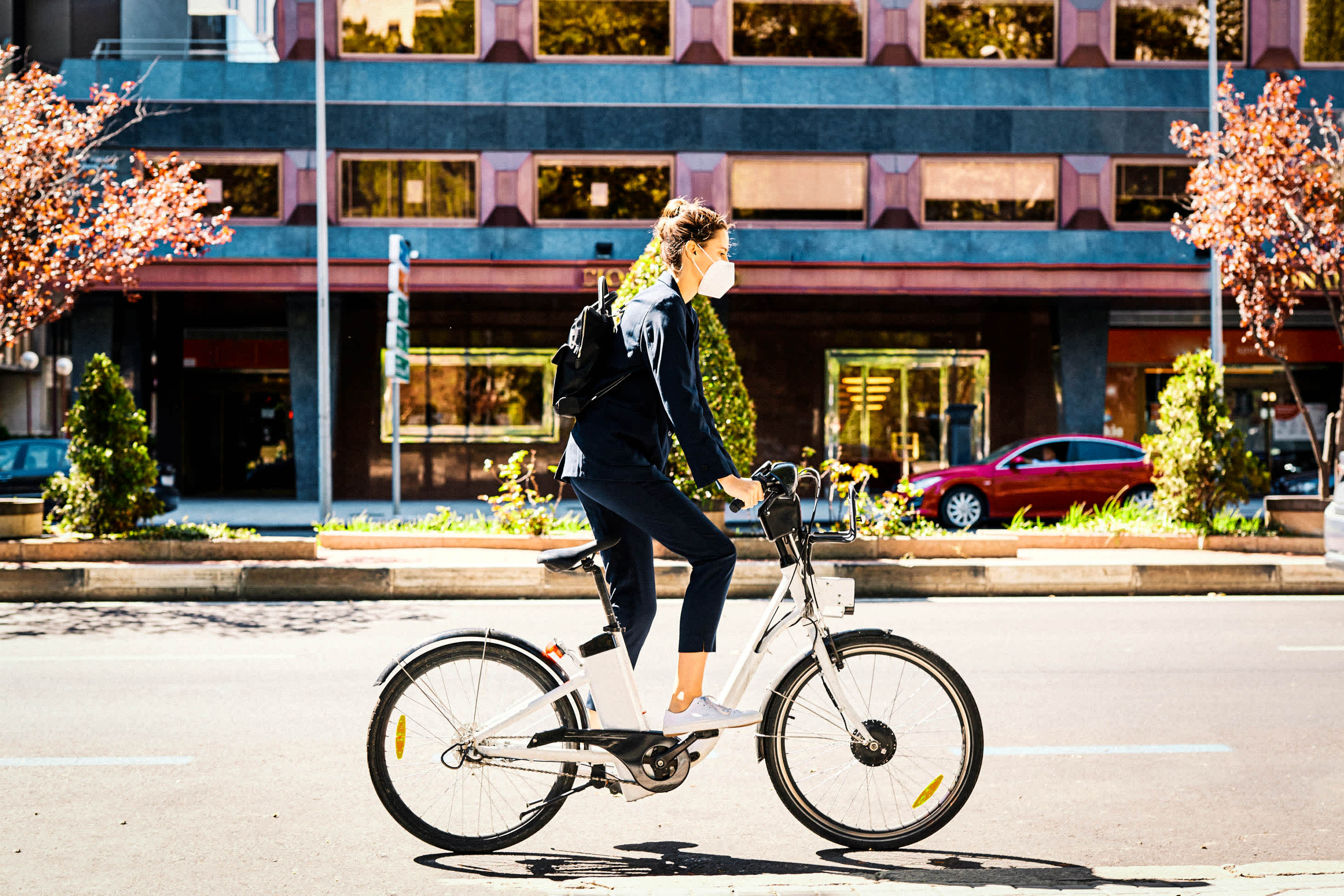 emergency funds in the age of covid-19: a woman riding a bike outside while wearing a face mask