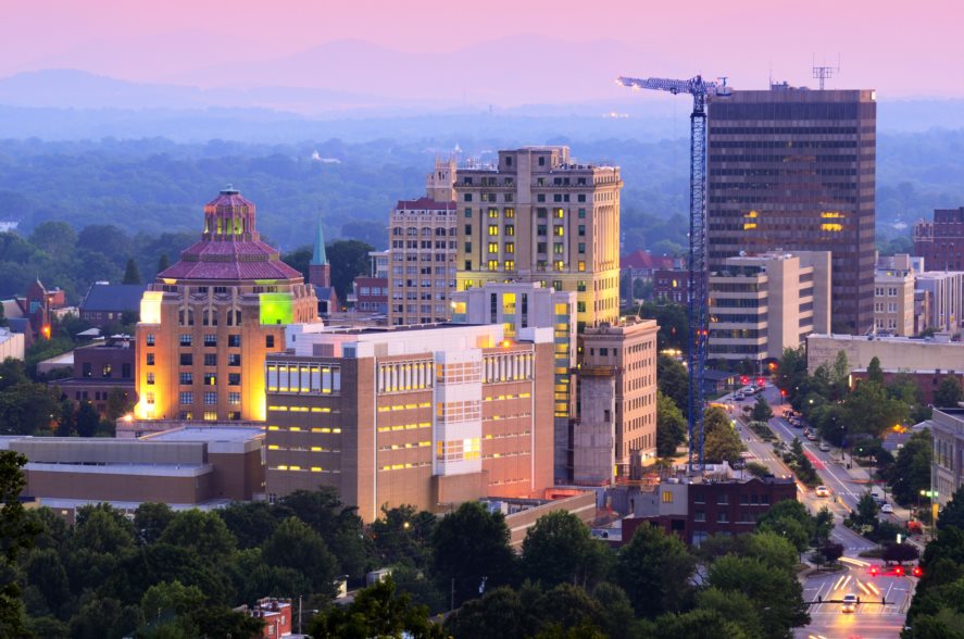 10 Best Cities in America for Single Parents - Downtown skyline of Asheville, NC with Appalachian mountains in the far distance. 