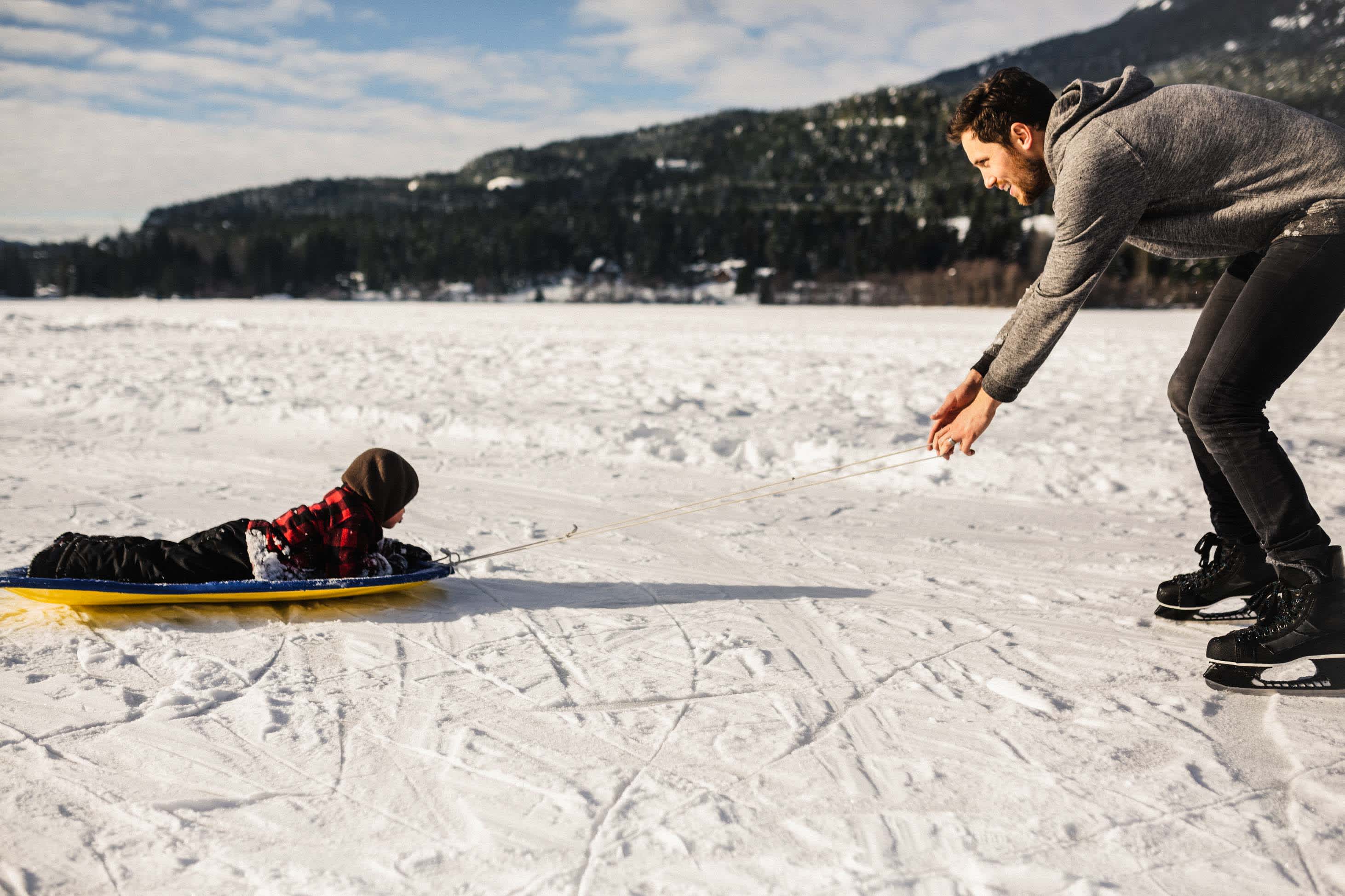 father pulling child on sled - winter quarterly financial check-in