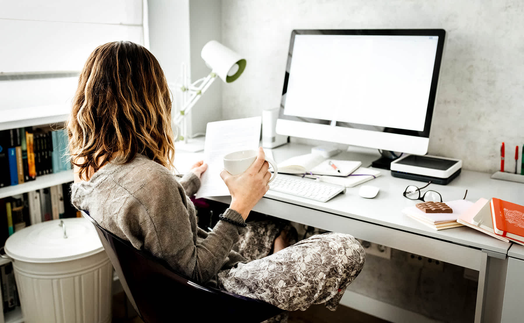 term vs whole life insurance - woman at a computer with paperwork and coffee