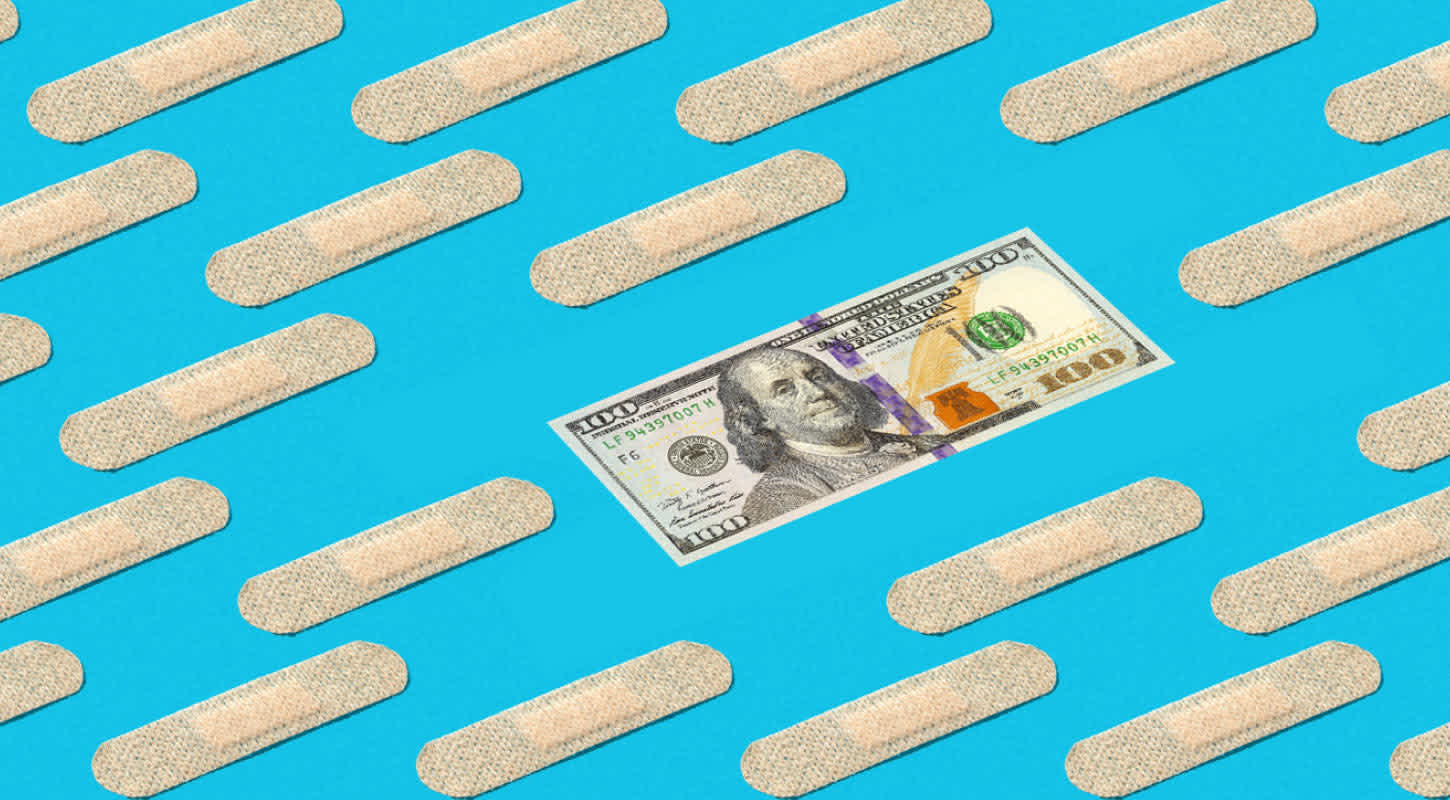 A one hundred dollar bill lays flat amidst multiple bandages.