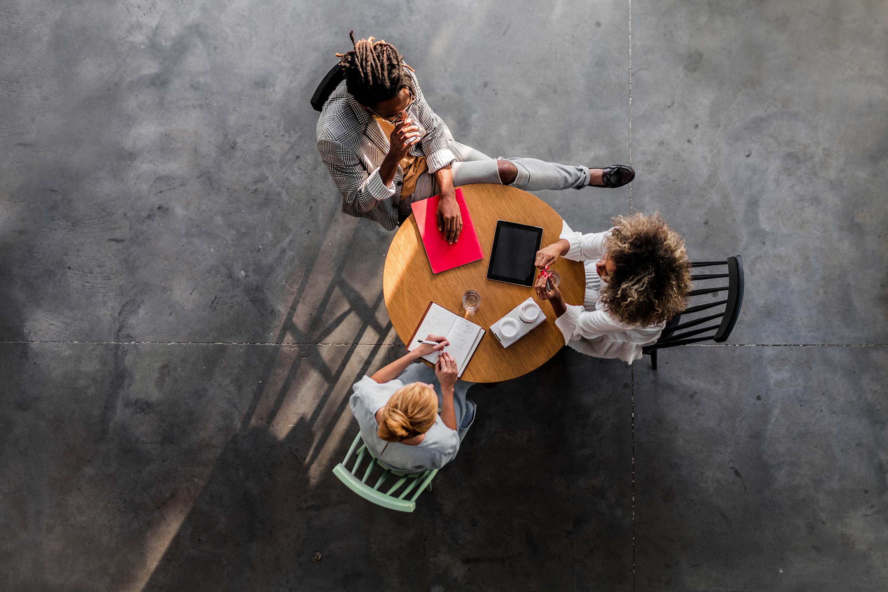 three women discussing business at a table - tax season updates for 2020 for parents