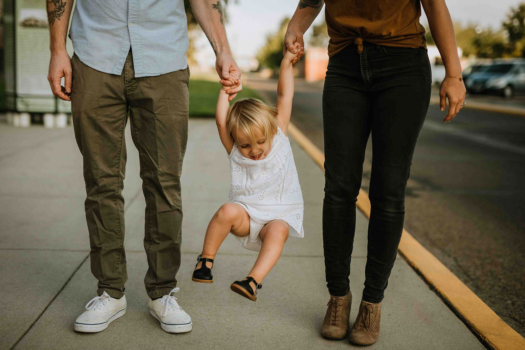 best way to save for college - parents swinging a toddler between them on a train platform