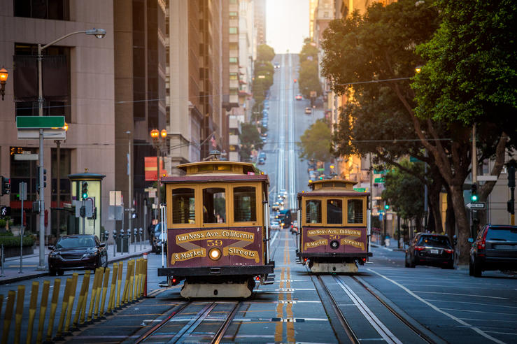 10 Family-Friendly Cities With the Best Public Transit - Two San Francisco Municipal Railway (Muni) trains traveling up a steep hill San Francisco, CA.