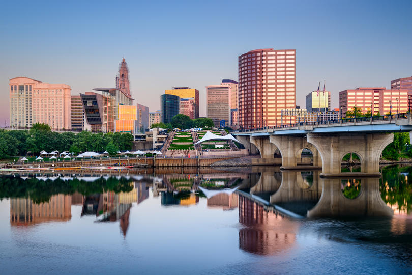 The Best-Paying Cities for Millennials - Hartford, Connecticut skyline and view of The Founders Bridge over the Connecticut River.