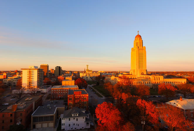 States with the best public schools - capitol building in Lincoln, Nebraska surrounded by trees with red fall leaves.