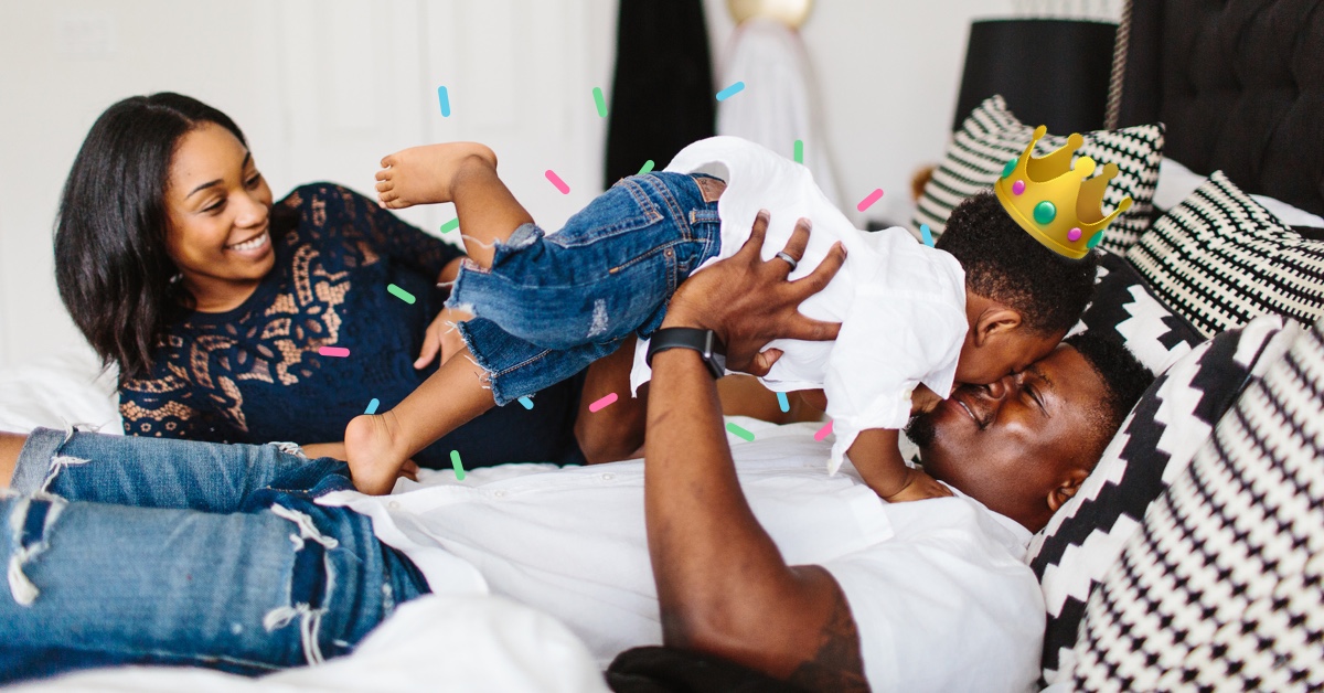 two parents and toddler lounging on bed - essential items every new parent needs