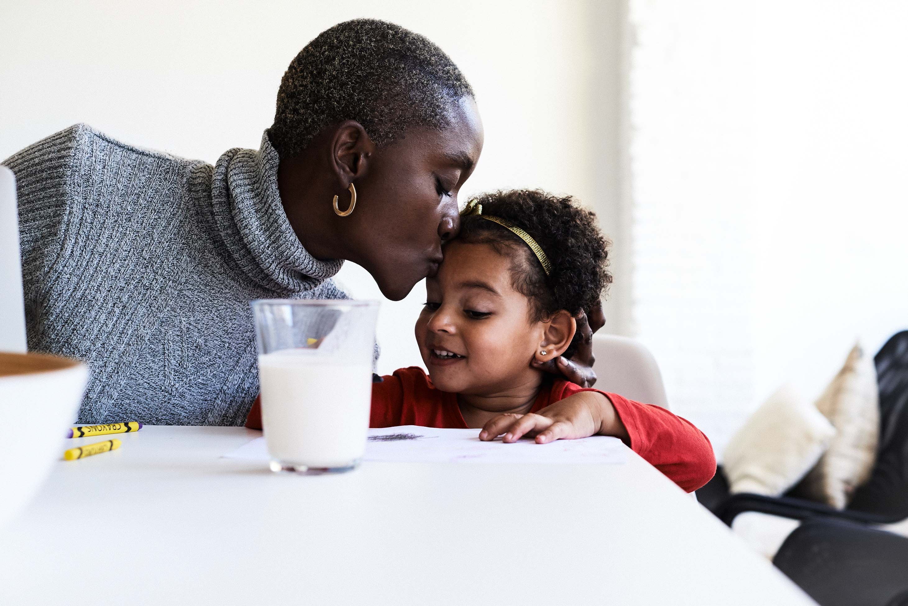coronavirus covid-19 financial moves to prepare - mother kissing daughter at kitchen table