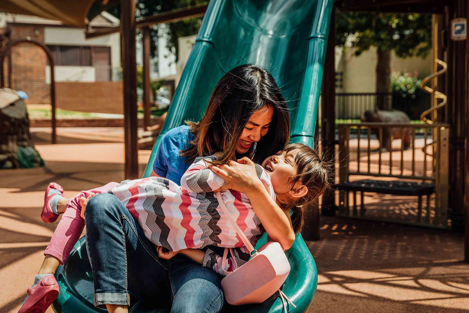 cities with the best work life balance - mother and child laughing on a playground slide
