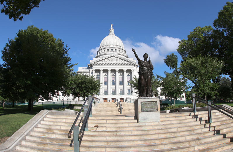 States with the best public schools - capitol building in Madison, Wisconsin with the statue of a woman depicting the state motto "forward" with her hand gesture in the foreground. 