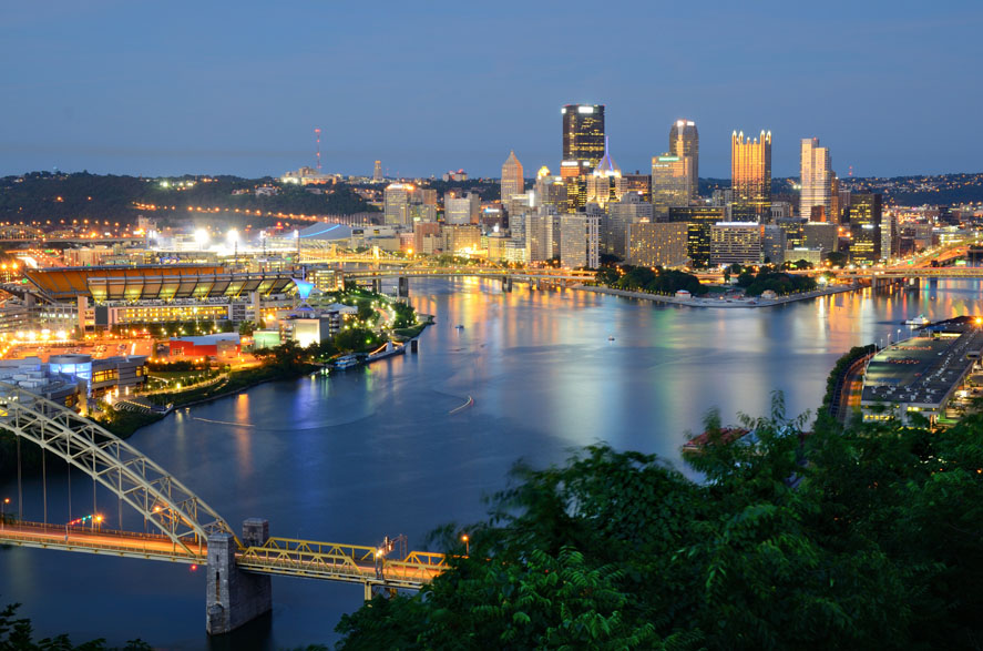 The Best-Paying Cities for Millennials - Pittsburgh, Pennsylvania waterfront skyline with the Fort Pitt yellow bowstring arch bridge in the foreground. 