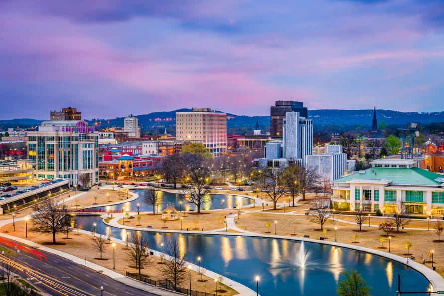 10 Best Cities in America for Single Parents - Skyline of Huntsville, AL with a pond filled walkway in the foreground. 