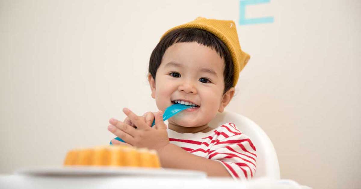 smiling baby in high chair - guide to budgeting for baby