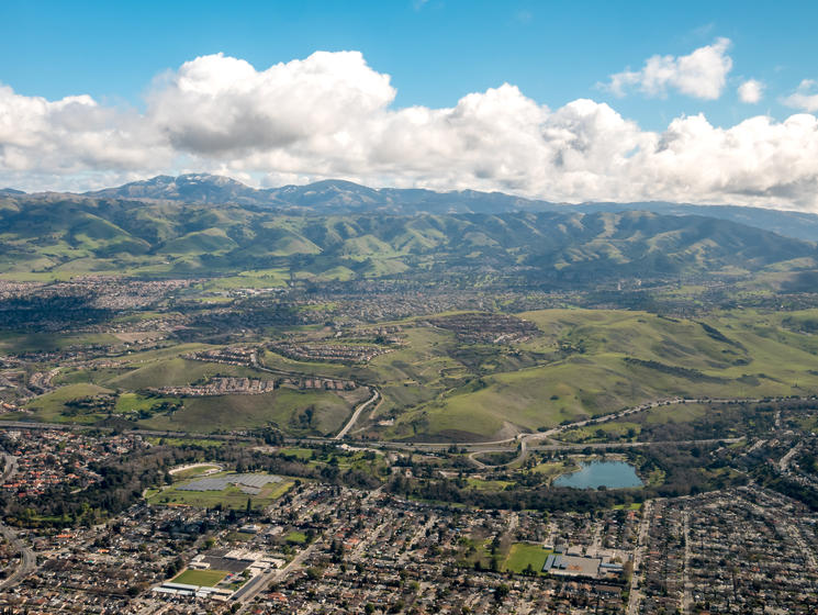 How Much Home Can Millennial Families Afford in These Top Cities? - San Jose, CA valley against a cloudy sky.