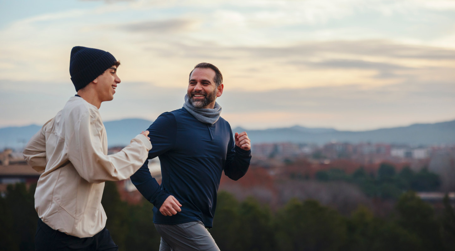 A father and sun enjoy jogging on a mountainous nature trail. 