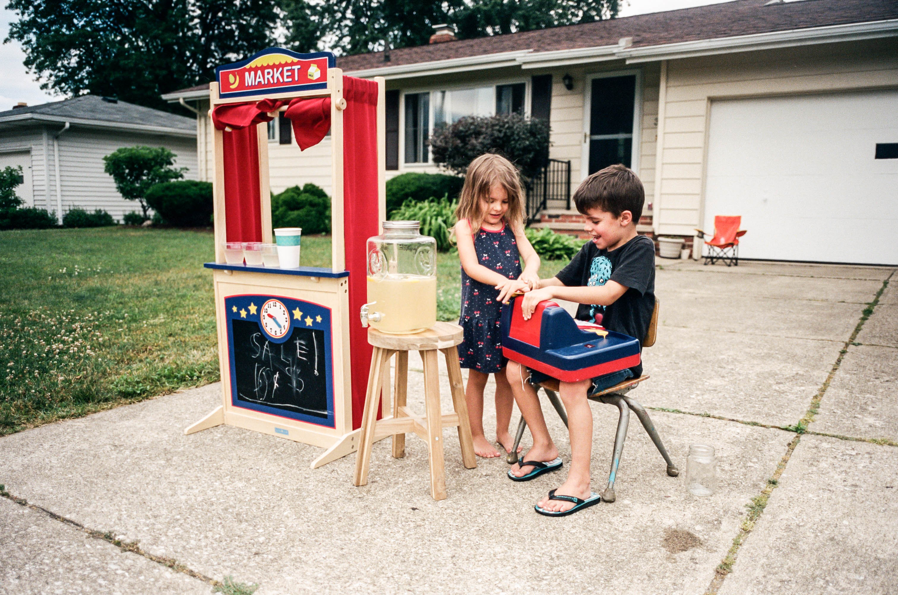 how to teach kids the value of a dollar - two kids at a lemonade stand