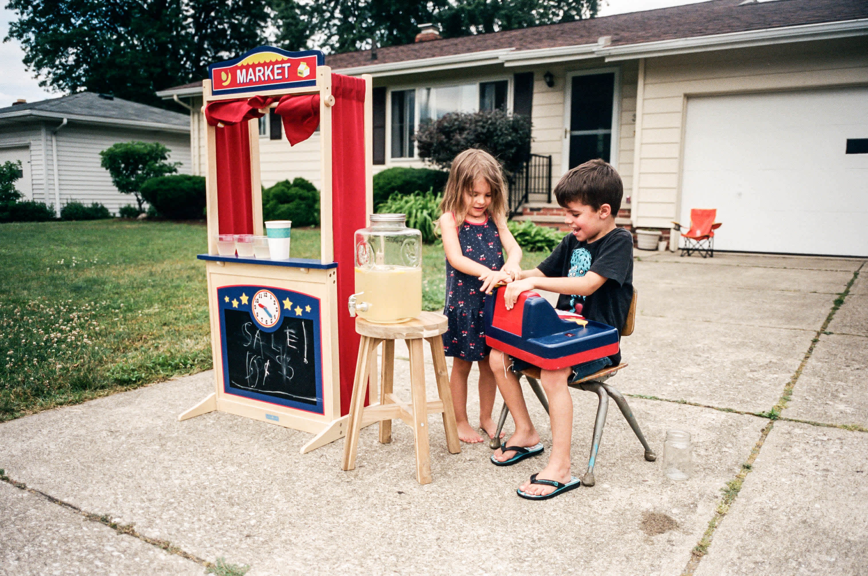 how to teach kids the value of a dollar - two kids at a lemonade stand