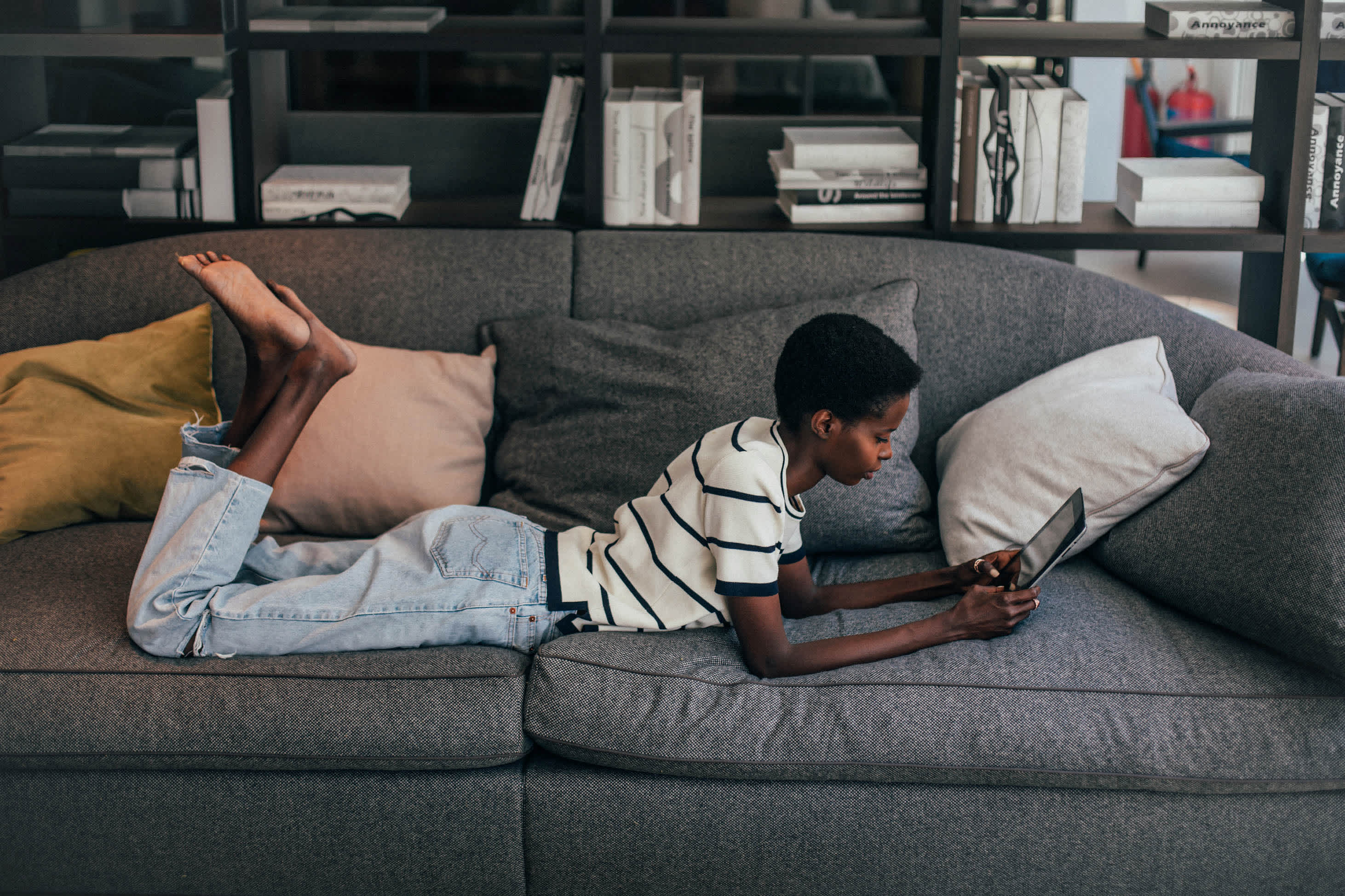 person in striped shirt and jeans relaxing on a couch with an iPad - how to be the executor of an estate