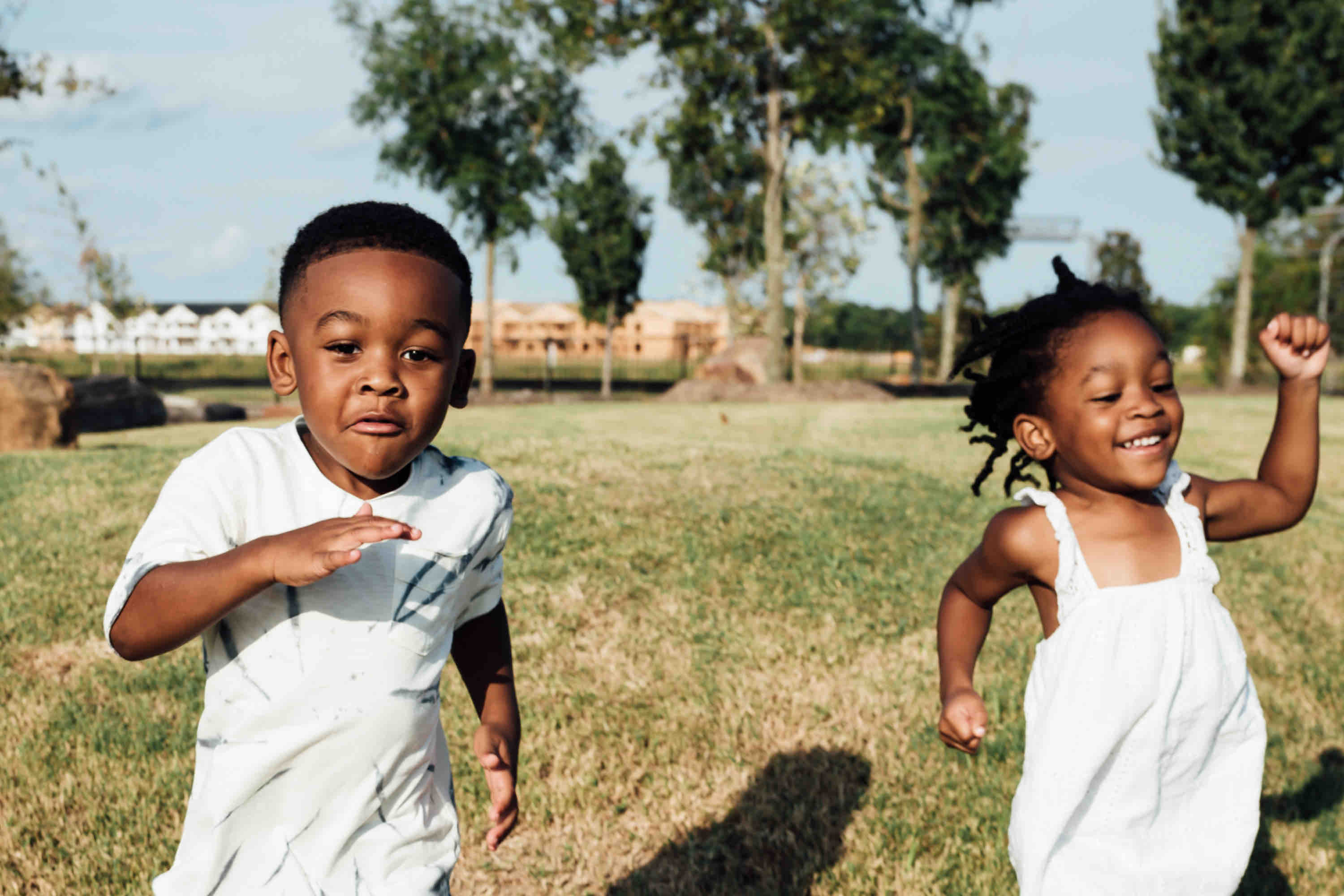 boy and girl running in field and smiling - spring financial to dos