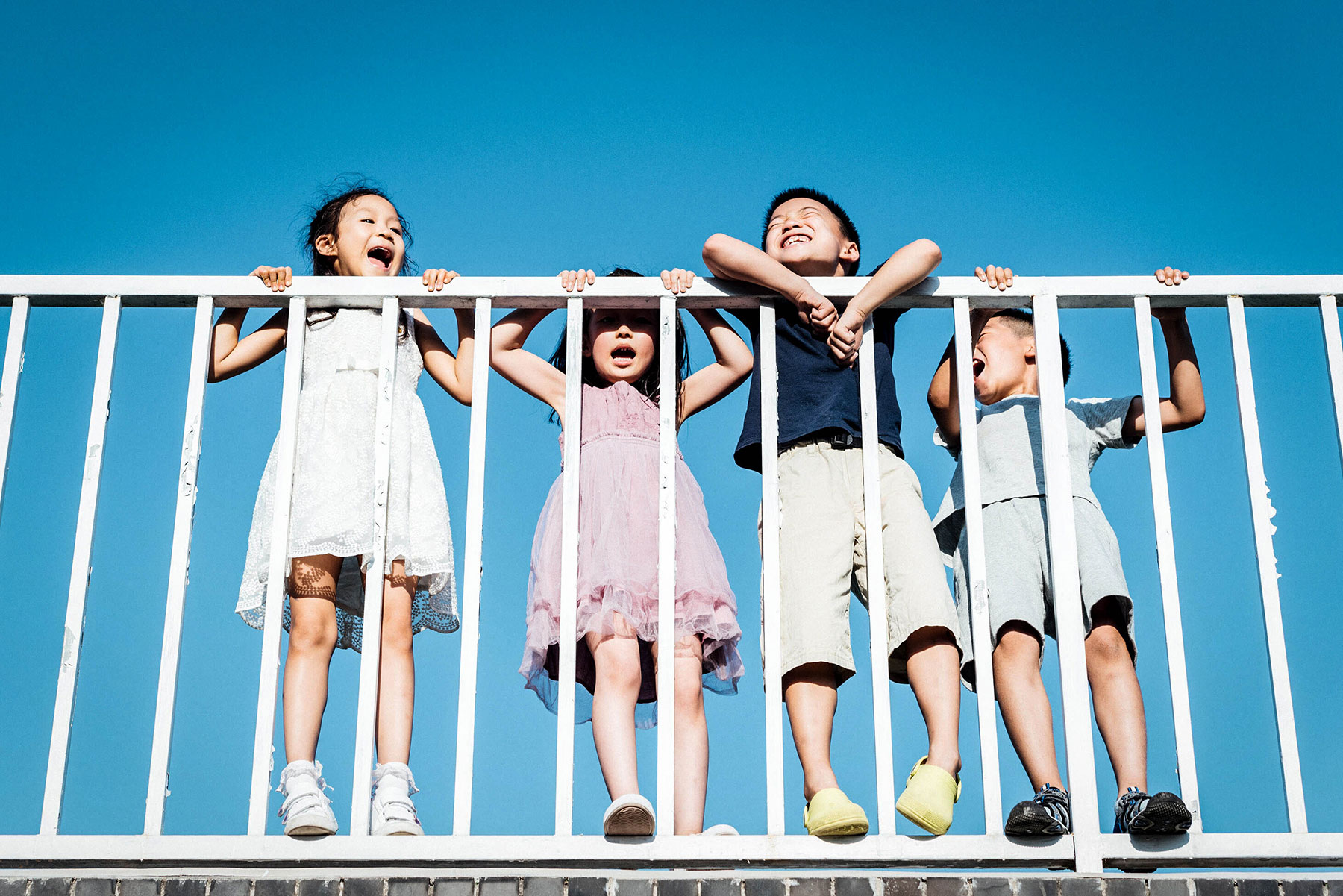 estate planning for blended families - four kids playing and yelling by a balcony