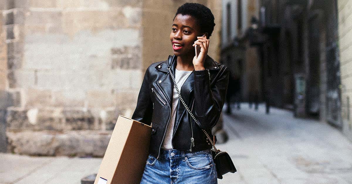 stylish woman carrying package and talking on phone - how to be a smart online shopper, tips from retail experts