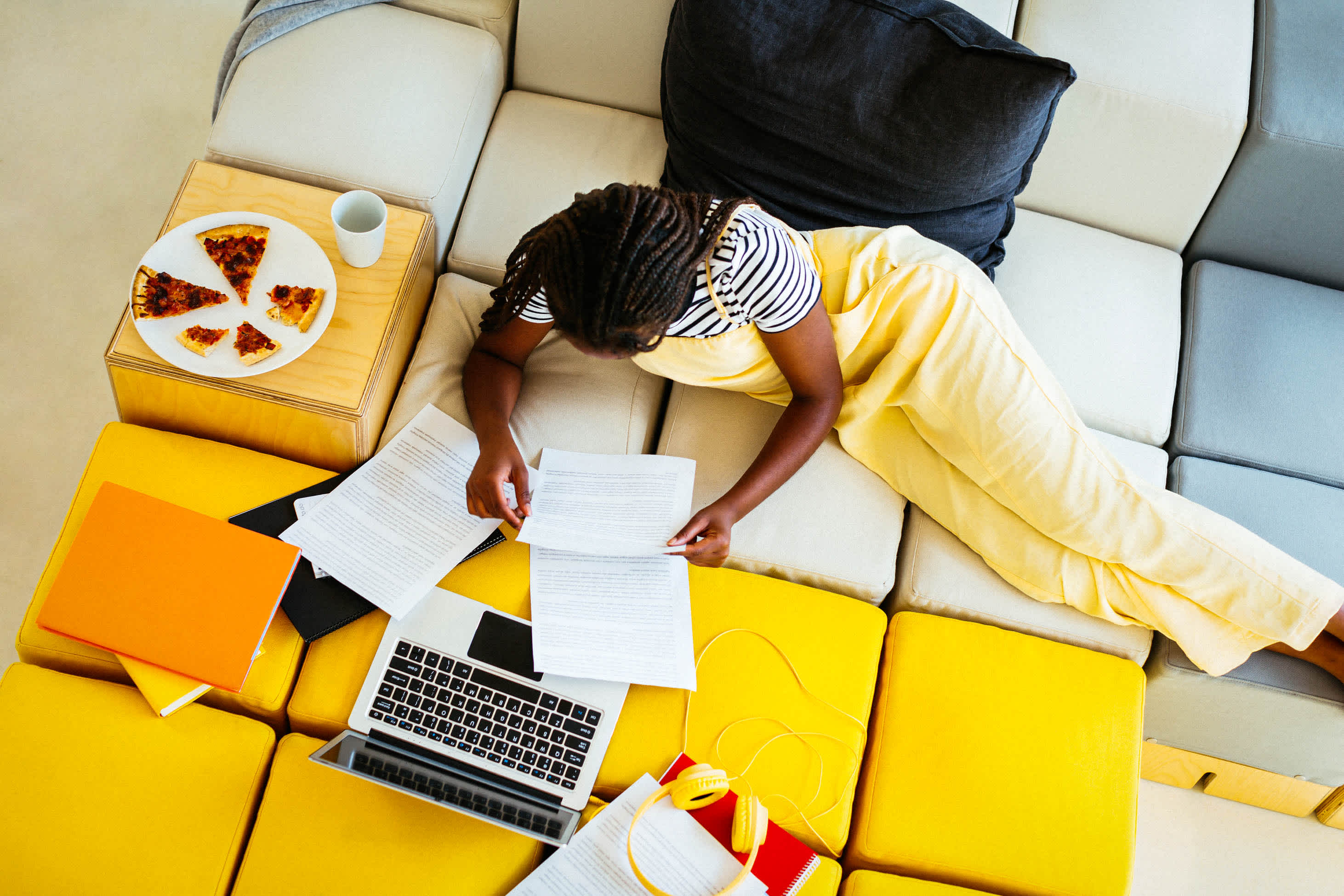 wills and life insurance - woman on couch with paperwork and computer