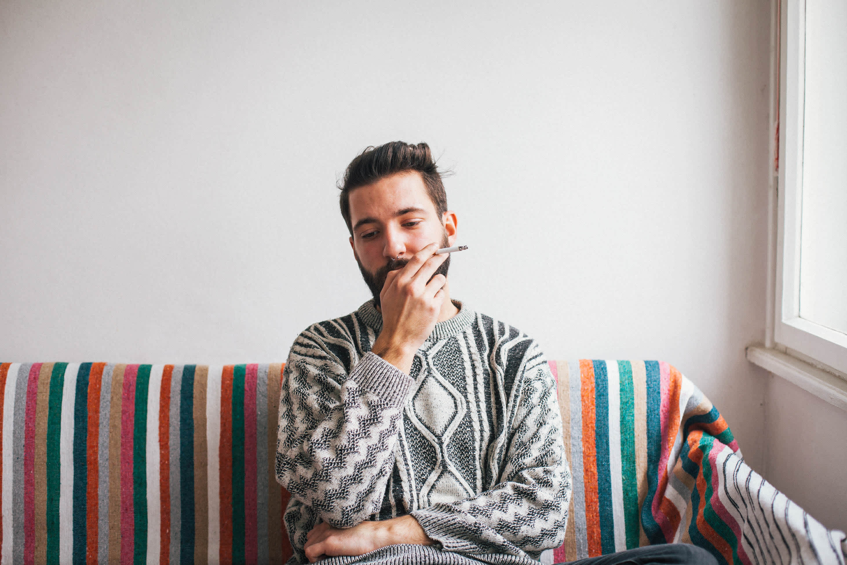 man smoking cigarette on couch