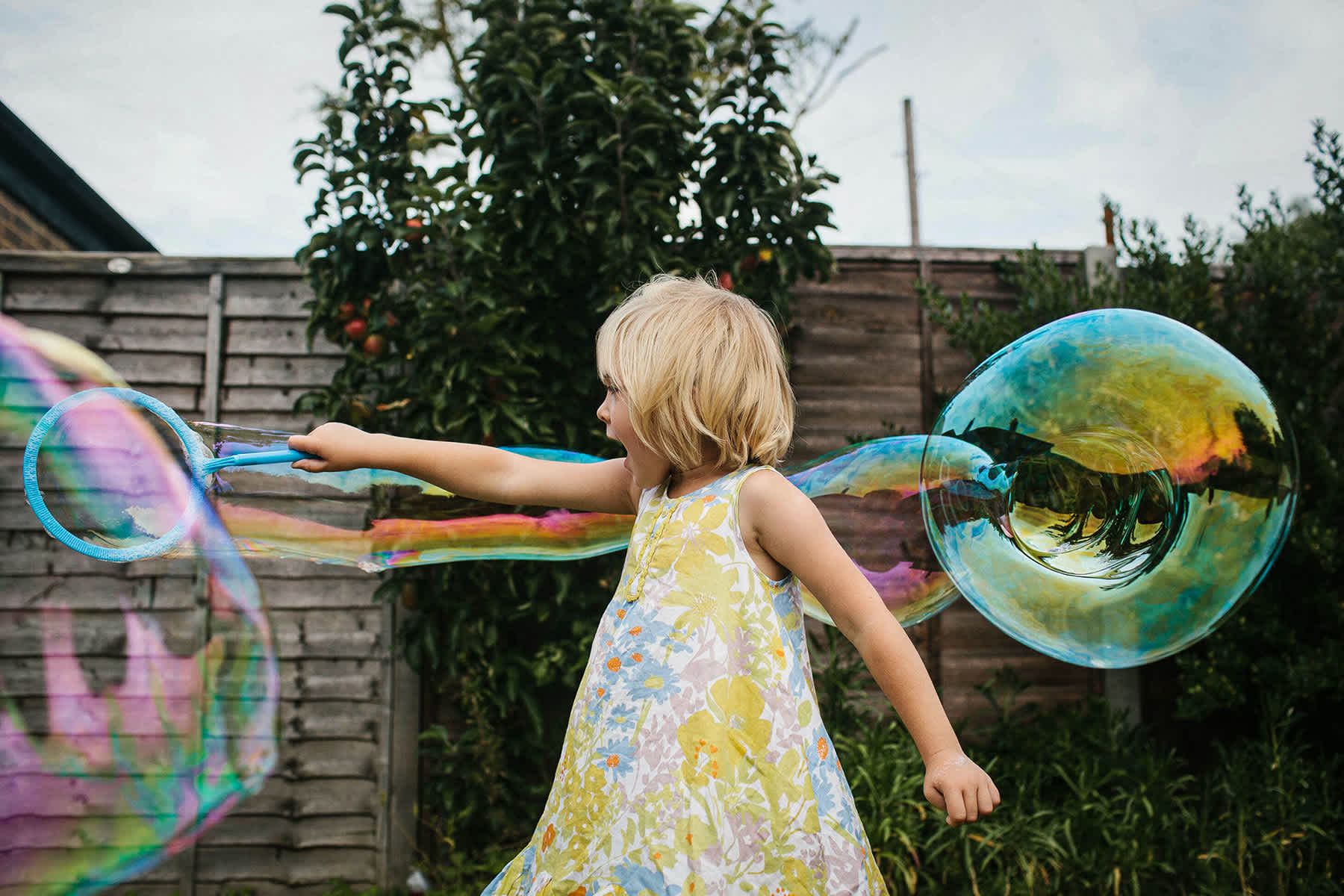 teaching charity to kids - girl playing outside with bubbles