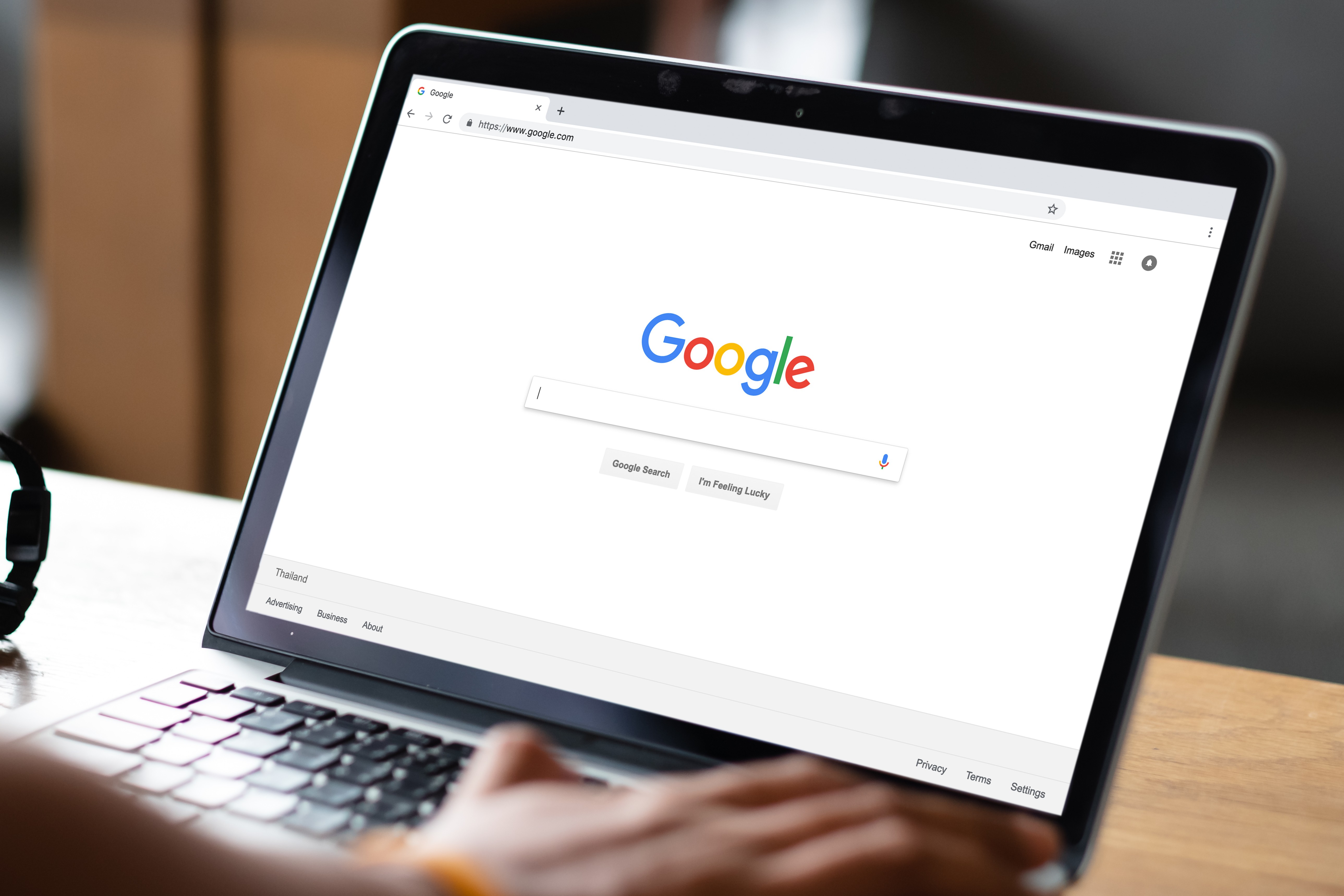 A laptop on a desk with the website Google on the screen.