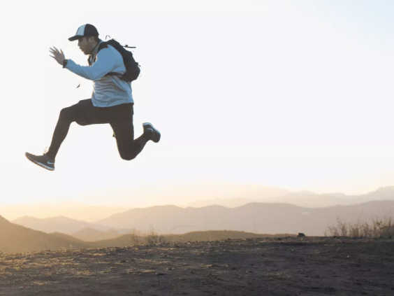 Man in baseball cap leaping into the air