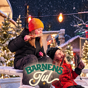 Två barn som äter långa, smala kakor utomhus på en snötäckt, upplyst julmarknad med texten ”Barnens Jul” över bilden.