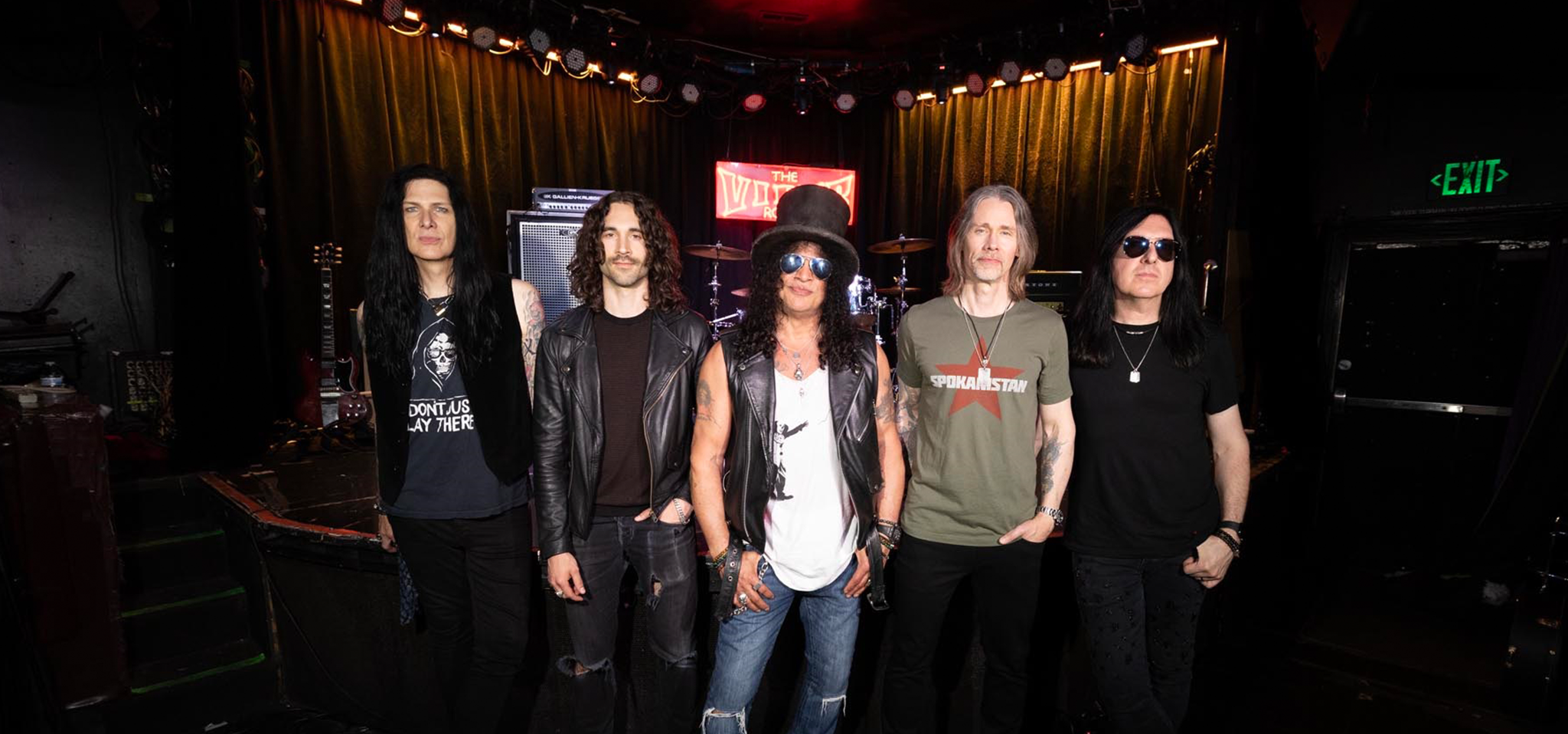 The band Slash featuring Myles Kennedy and the Conspirators standing on a stage.