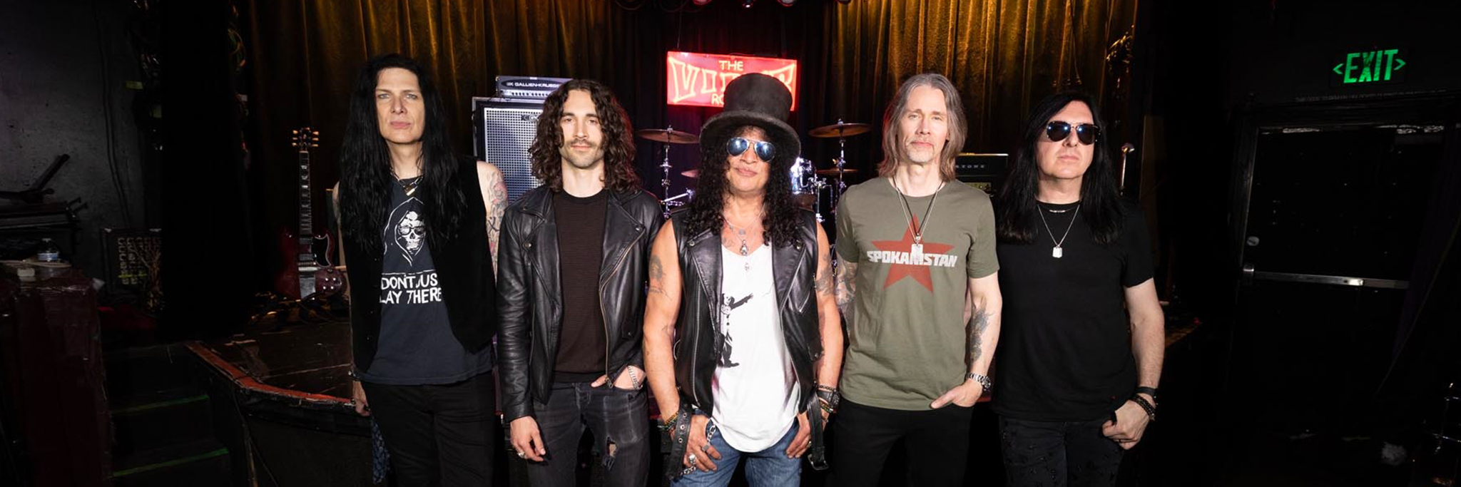 The band Slash featuring Myles Kennedy and the Conspirators standing on a stage.