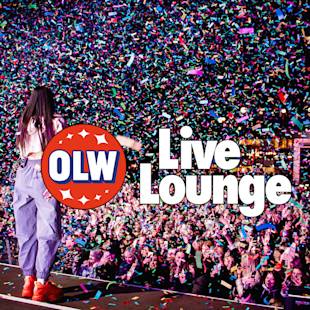 En artist står på scenen inför en jublande publik under fallande konfetti, med texten "OLW Live Lounge" på en framträdande plats.