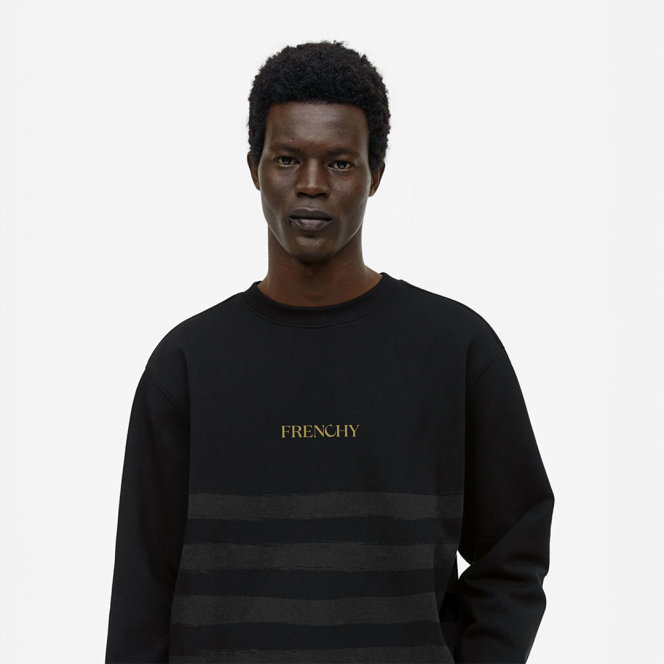 A model wearing a Frenchy branded knit crewneck sweater, black with subtle grey horizontal stripes, and "Frenchy" embroidered across the chest.