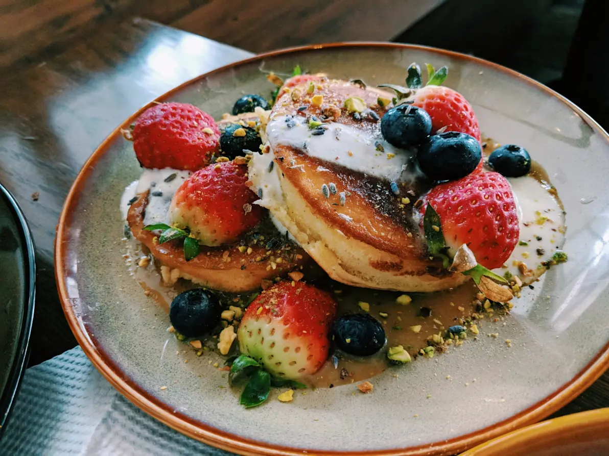 pancake with strawberries, blueberries, and syrup