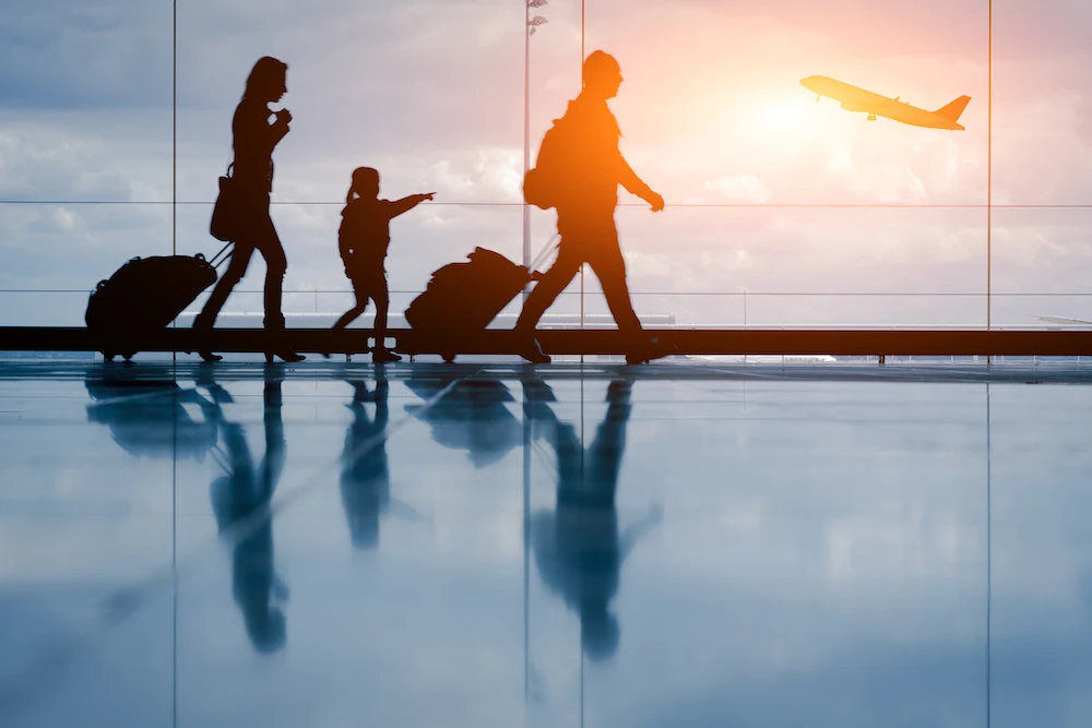 silhouette of a family of tree in an airport and an airplane