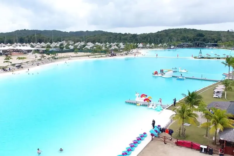 An aerial view of Treasure Bay Bintan's Crystal Lagoon, a large man-made pool with bright blue water and surrounding powdery white sand.