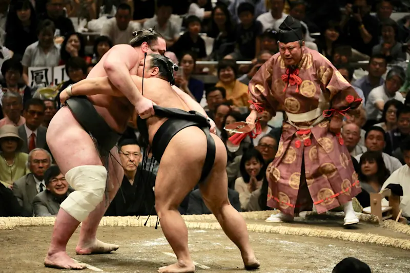 Two men sumo wrestling in a sumo ring in Tokyo