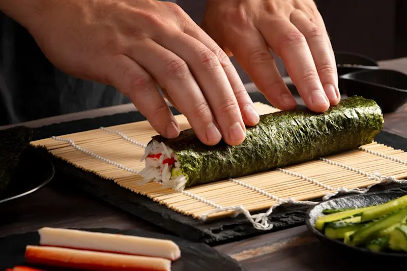 Hand-rolling sushi on a table