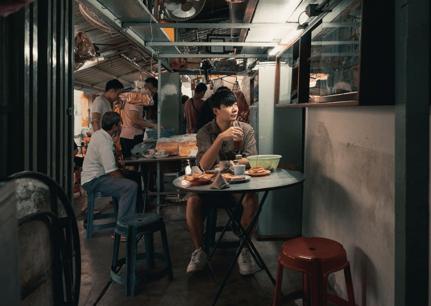 a man sitting in front of a round table with food